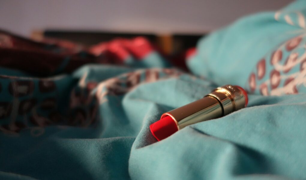 a red lipstick resting on a blue blanket