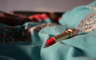 a red lipstick resting on a blue blanket