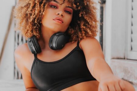 a woman wearing headphones sitting on a ledge
