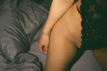 a naked woman sitting on top of a bed