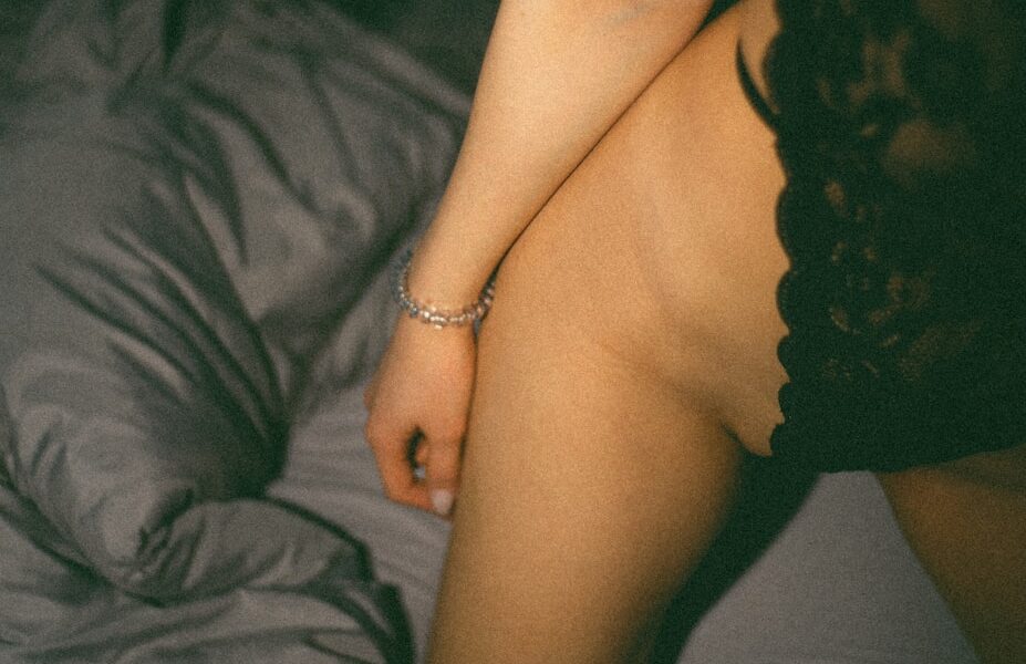 a naked woman sitting on top of a bed