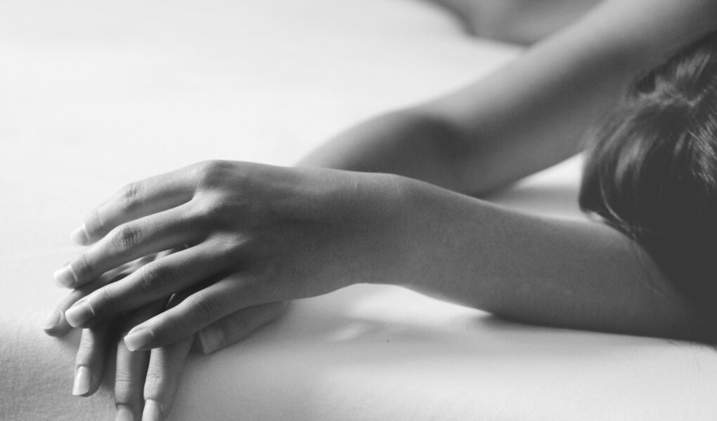 grayscale photo of person lying on bed