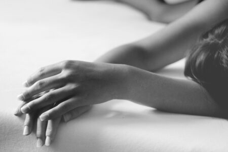 grayscale photo of person lying on bed